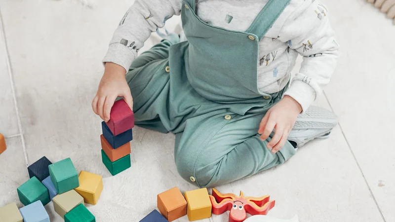 Drewniane klocki i kolorowe klocki Duplo obok siebie na jasnej podłodze